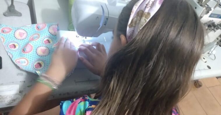 menina costura máscaras em projeto social