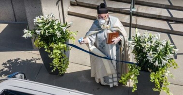padre benze fiéis com pistola dágua