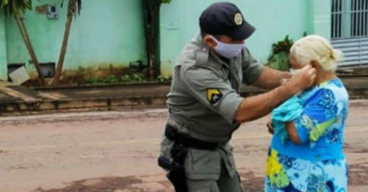 policial ajuda idosa a botar mascara