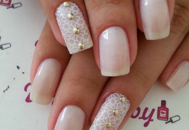 modelo de unhas decoradas com pedras douradas e renda