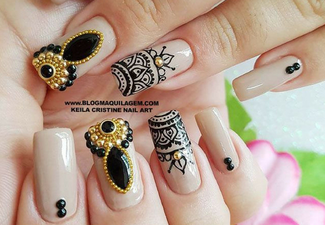 modelo de unhas decoradas com pedras grandes preto dourado